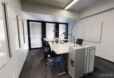 Bright conference room with multiple whiteboards and rolling storage units.