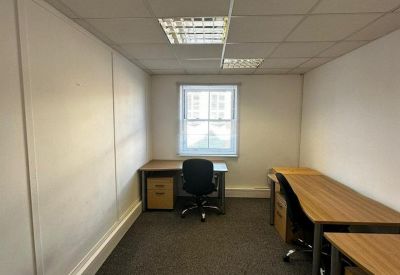 Private office suite featuring wooden desks and a window view.