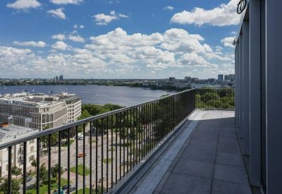 Outdoor roof terrace with a metal railing overlooking the city and lake.