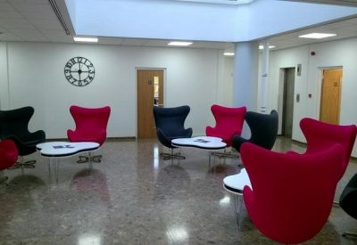 Lobby area with modern red and black chairs and polished tile floors.