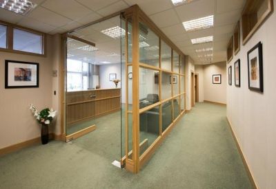 Professional reception area with a wooden desk and glass partitions.