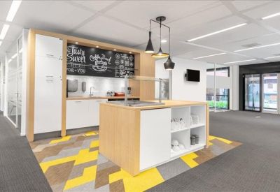Communal kitchen and breakout area with a central island and colorful geometric floor tiles.