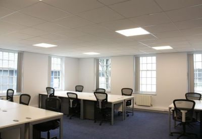 Bright open-plan office suite with white desks and ergonomic black chairs.