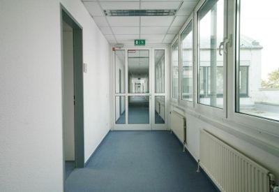 Bright white corridor with large windows and blue carpeting.