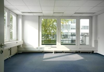 Empty private office suite with large windows and blue carpeting.