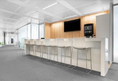 Communal break area with a long white breakfast bar and wood-paneled wall.