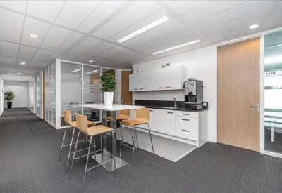 Bright communal kitchen area with high-top seating and coffee facilities.