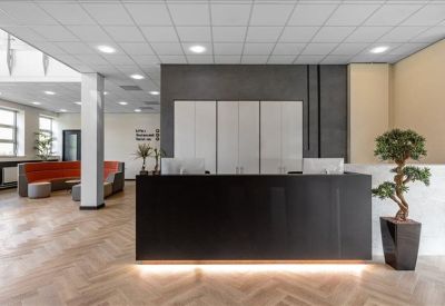 Clean, professional reception area with a dark wood desk and potted tree.