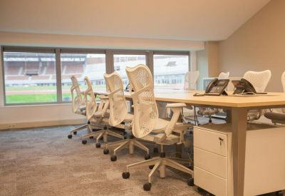 Bright workspace with ergonomic white mesh chairs and views of the stadium.