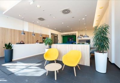 Minimalist reception area with a white desk, wood-paneled feature wall, and yellow armchair.