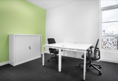 Private two-person office suite with a green feature wall and natural light.