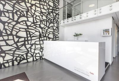 Minimalist reception area featuring a white desk and a bold black and white patterned wall.