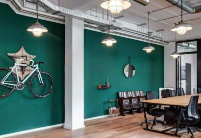 Professional meeting room with a dark teal accent wall and long wooden conference table.
