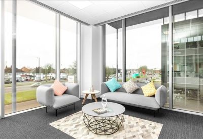 Minimalist meeting room with a wooden table and black mesh chairs.