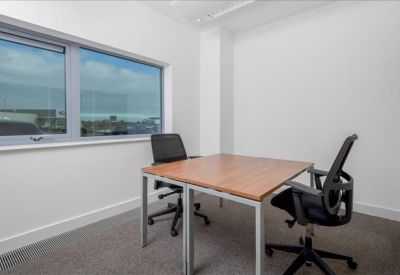 Private internal office featuring a wooden desk and two black ergonomic chairs.