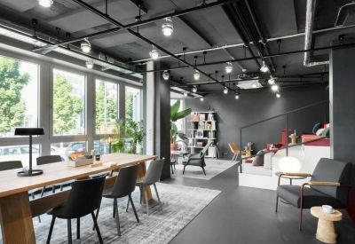 Modern lounge area with tiered seating, black industrial ceilings, and large windows.