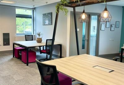 Modern open-plan workspace at The North Colchester Business Centre, 340, The Crescent with pink chairs.