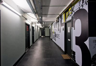 Industrial style corridor with polished black floors and large graphic wall art.