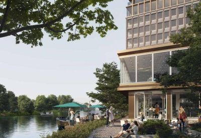 Communal outdoor terrace by the water with seating and green umbrellas.