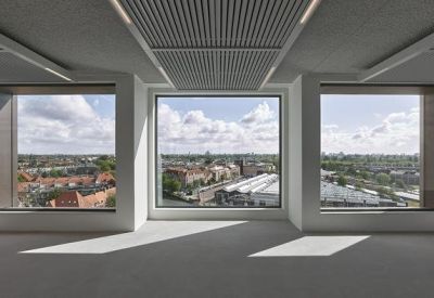 Empty open-plan office space featuring large panoramic windows with city views.