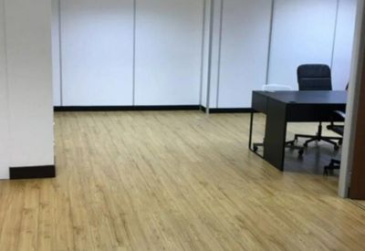 Internal office suite featuring wood-effect flooring and white partition walls.