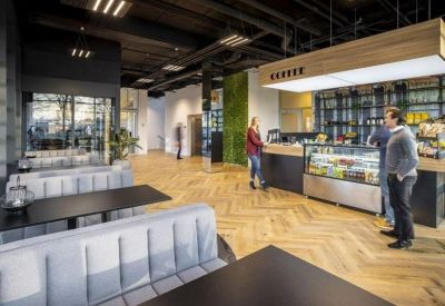 On-site cafe featuring a wooden service counter, bar seating, and herringbone flooring.