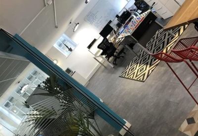 Wide view of a modern office space including a foosball table and indoor plants.