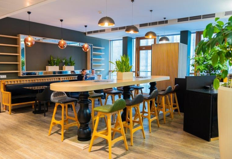 Modern communal workspace at 19, Hammer Straße with high-top tables and bright yellow stools.