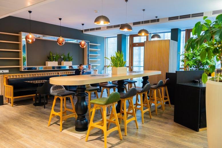 Modern communal workspace at 19, Hammer Straße with high-top tables and bright yellow stools.