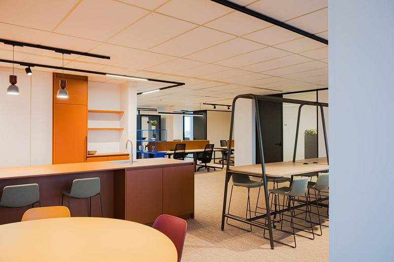 Exterior view of the glass-façade Brand Whitlocklaan building, showing a reflective surface and modern architecture.