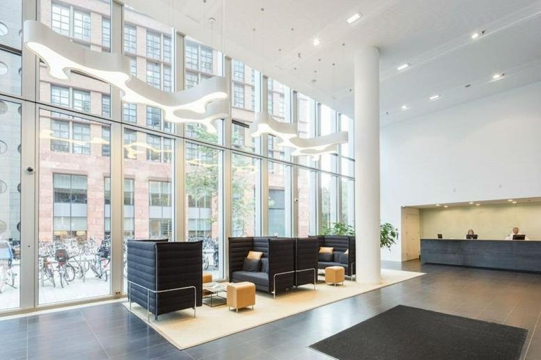 Spacious communal lounge with floor-to-ceiling windows and contemporary sculptural lighting.