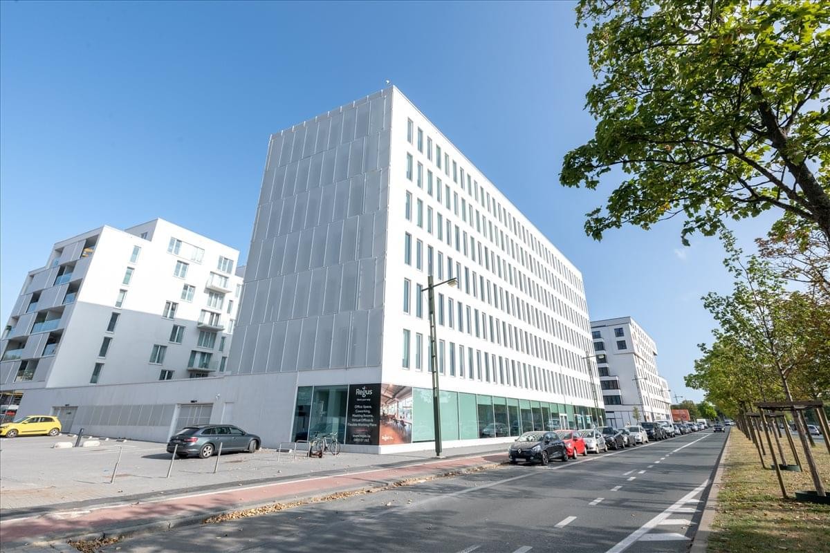 Exterior view of the modern white-facade office building at Boulevard Industriel 9, Anderlecht.