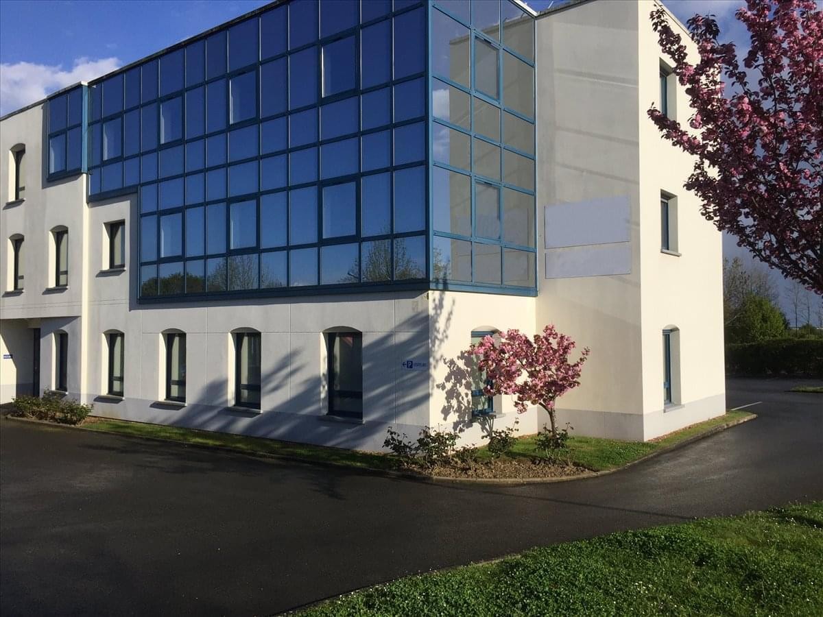 Modern building exterior at Le Mans, Technopôle Université, 28 Rue Xavier Bichat with glass facade and flowering trees.