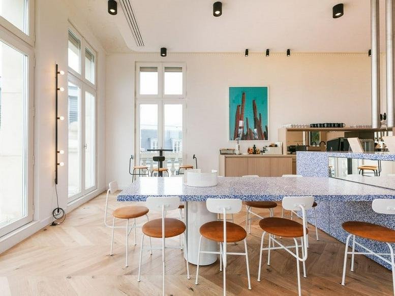 Spacious communal dining area with a blue terrazzo table at Spectrum, Boulevard Bischoffsheim 12-21.