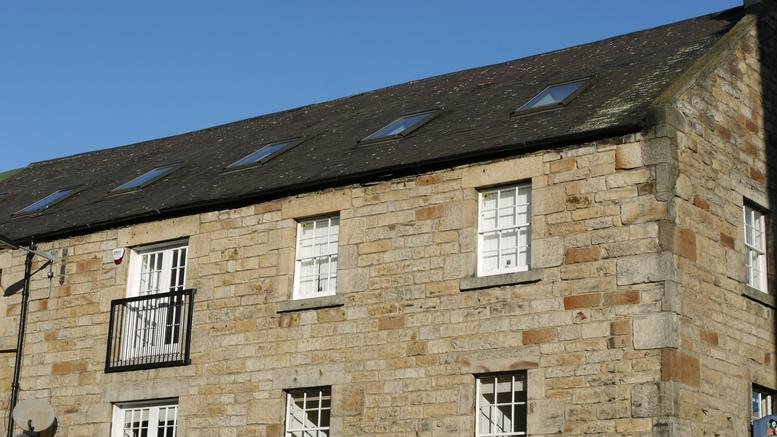 Stone exterior of The Whisky Bond featuring traditional windows and roof lights.