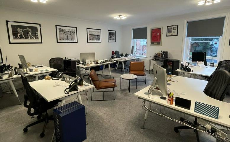 A professional open-plan workspace at 55 Chislehurst Road with multiple desks and framed wall art.