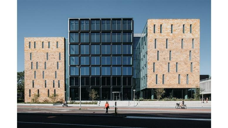 Modern exterior view of the stone and glass facade at Fred. Roeskestraat 100, Amsterdam.
