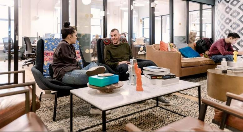 Spacious communal lounge at Axel-Springer-Platz 3 with modern furniture and marble coffee table.