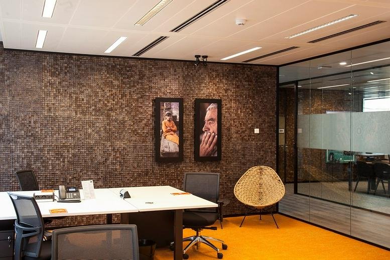 Private office space featuring a cork feature wall and round wicker chair.