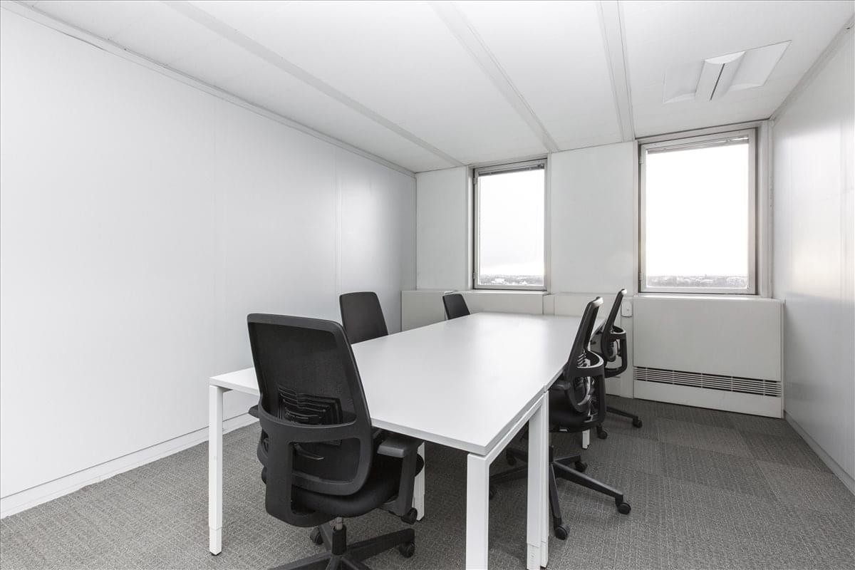 A professional six-person meeting room at Bureaux Europe, 20 Place des Halles with white desks and black mesh chairs.