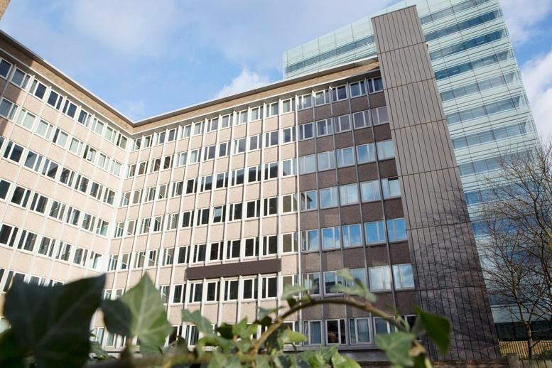 Exterior view of the multi-story Davis House building facade with modern glass and brown paneling.