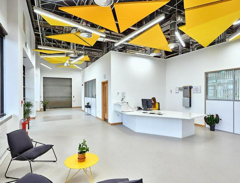 Spacious reception at Future Space, UWE Campus North Gate featuring yellow geometric ceiling baffles.