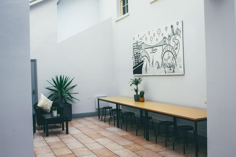 Communal breakout area at Kings House, 14 Orchard Street, with long wooden tables and skylights.