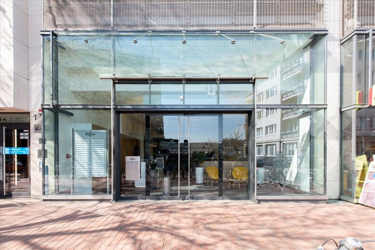 Exterior glass facade and main entrance of Ottenser Hauptstr. 2-6.