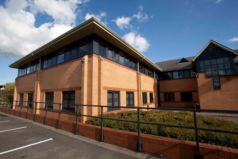 Exterior view of the brick-built Units 1-5, West Point Row with a paved parking area and blue sky.