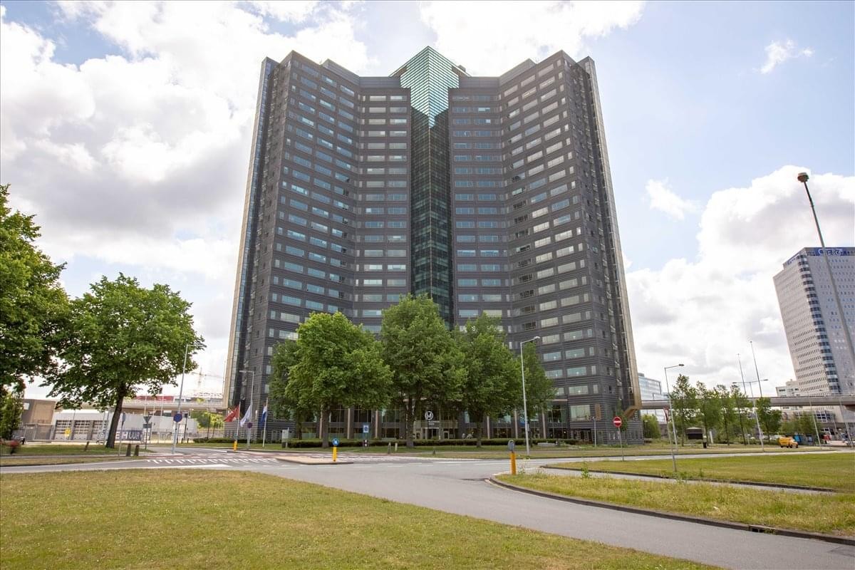 Exterior view of the tall, dark-glass Millennium Tower with its distinctive green pyramid roof crown.