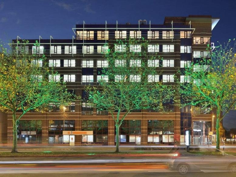 Evening exterior view of the modern brick and glass facade at Schutterspoort, Schipholweg 55-89.