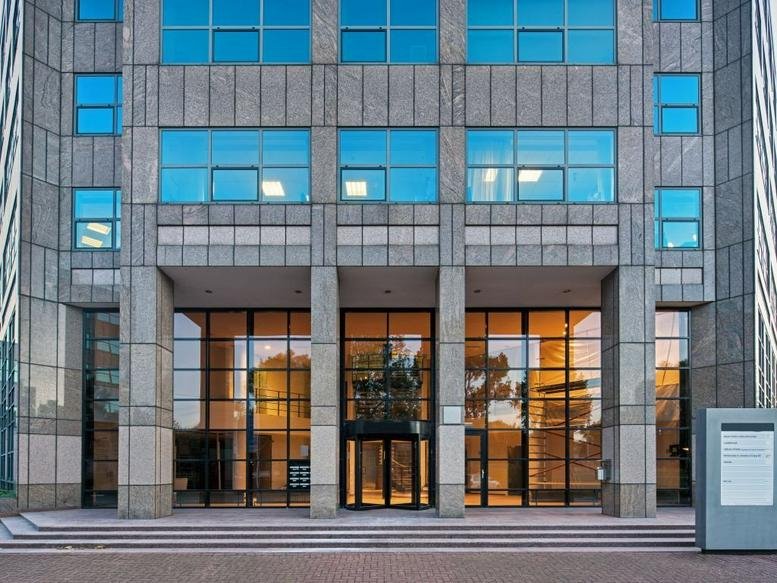 Exterior view of the modern stone and glass facade of Spring, Overschiestraat 186.