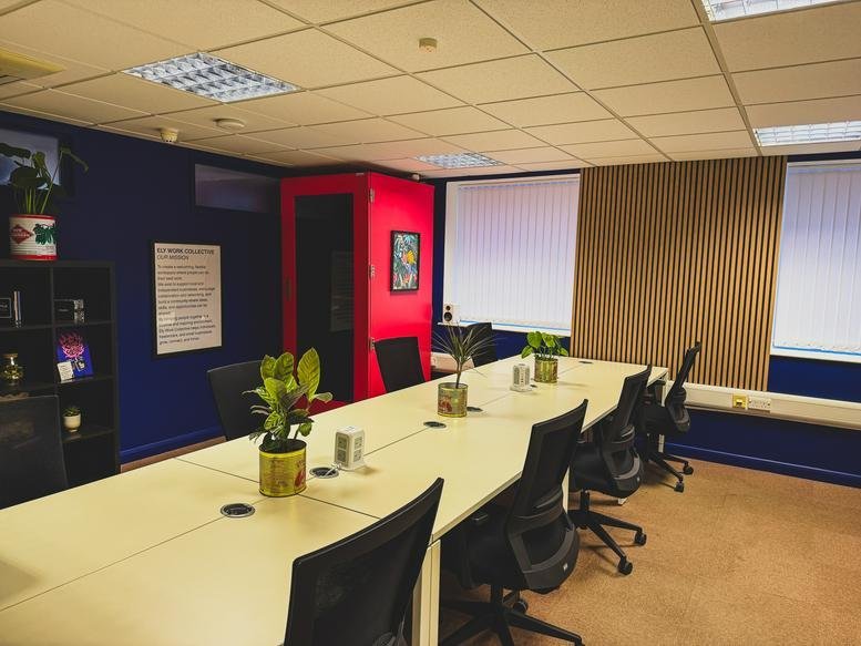 Interior view of a large meeting room with a long table and chairs