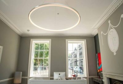Reception area with twin windows, a round halo light, and ornate wall detailing.